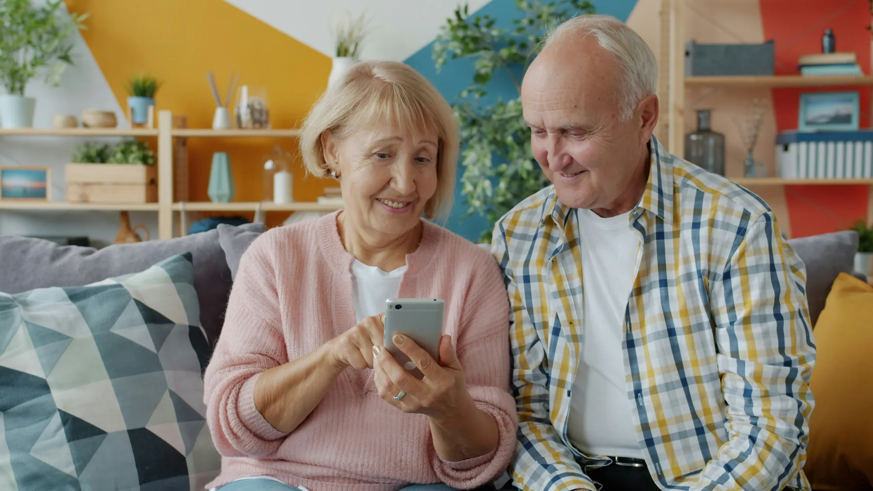 Residents smiling while using a mobile phone at home